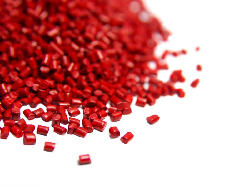 Red plastic polymer granules isolated on white